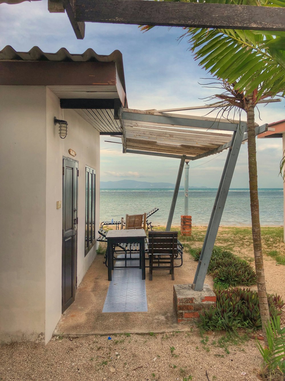 wooden table and chair near house at the beach