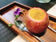Tropical passion fruit pulp with seeds, served in a clear jar with a spoon.
