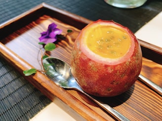 Tropical passion fruit pulp with seeds, served in a clear jar with a spoon.