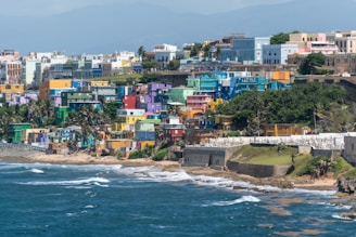 Colorful buildings on bluff over shoreline in daytime in Puerto Rico.