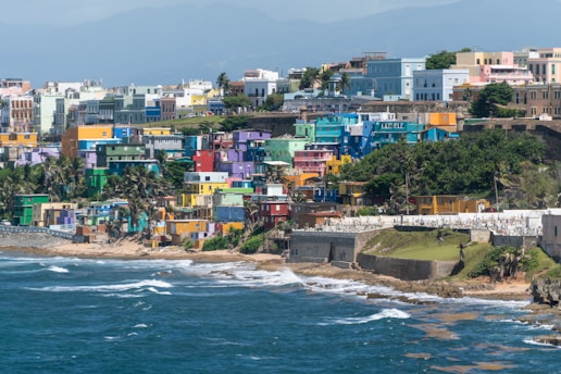 Colorful buildings on bluff over shoreline in daytime in Puerto Rico.