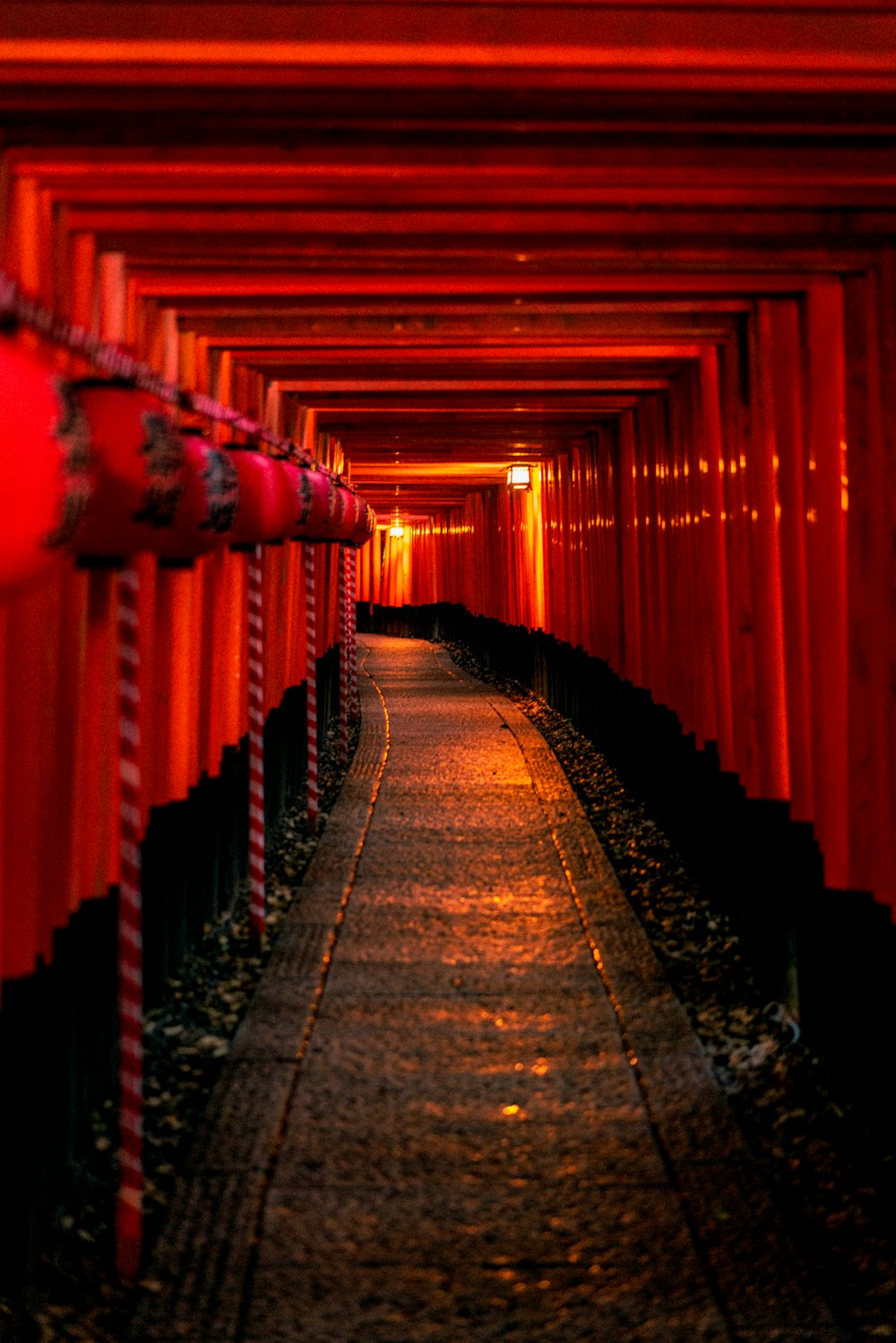 a tunnel of red and black poles and lights