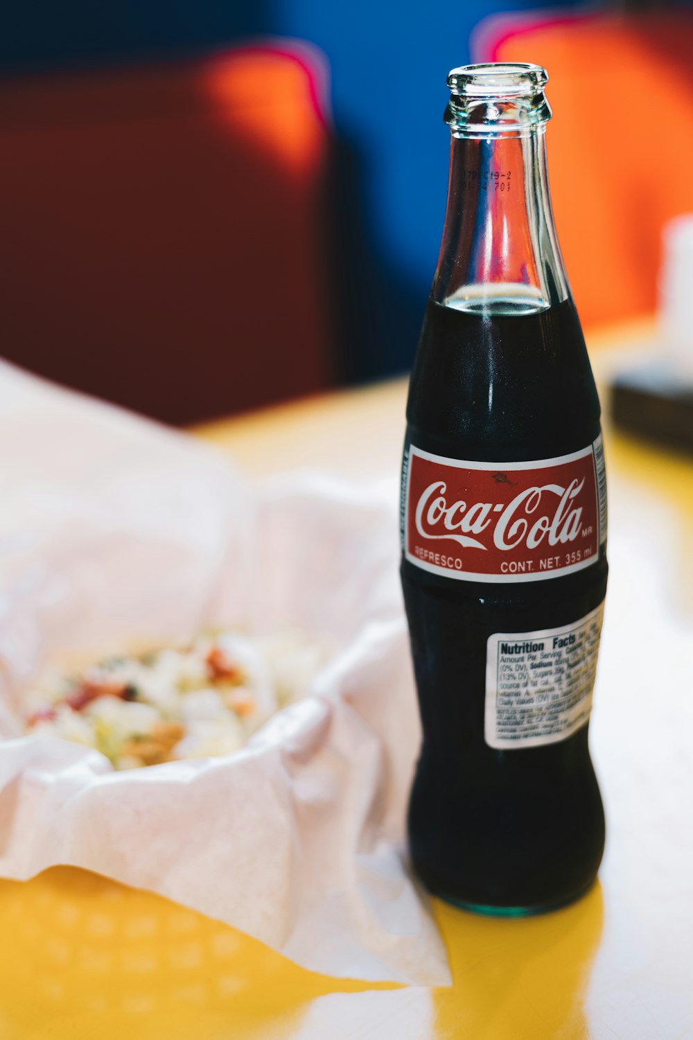 a bottle of coca cola sitting on top of a table