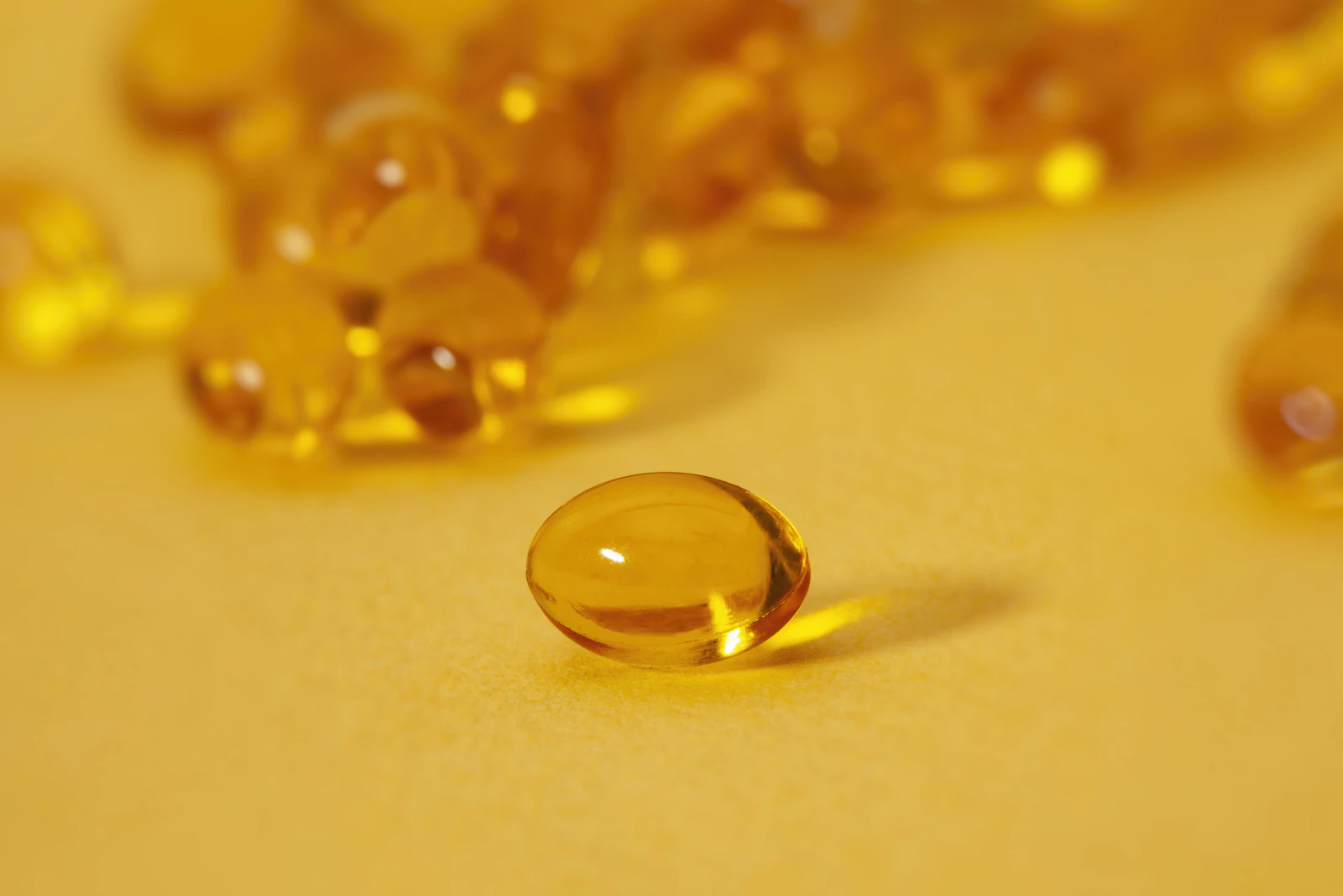 Close-up of golden vitamin D supplement gelcaps