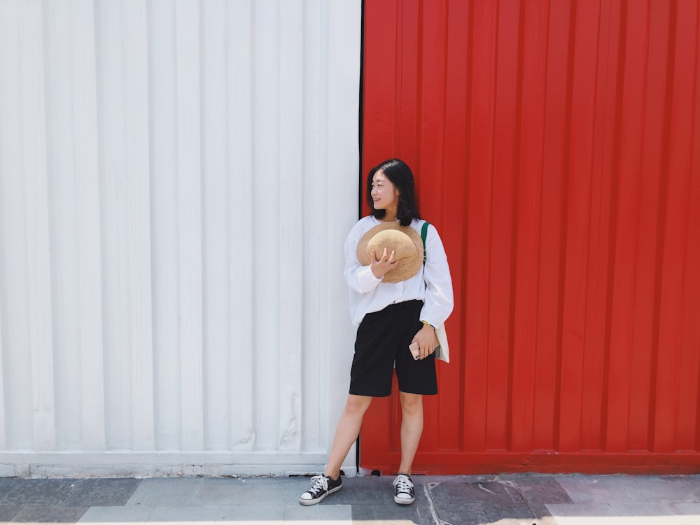 women near a red and white wall during daytime