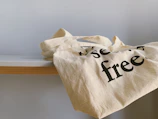 Close-up of custom branded tote bags displayed on a wooden table.