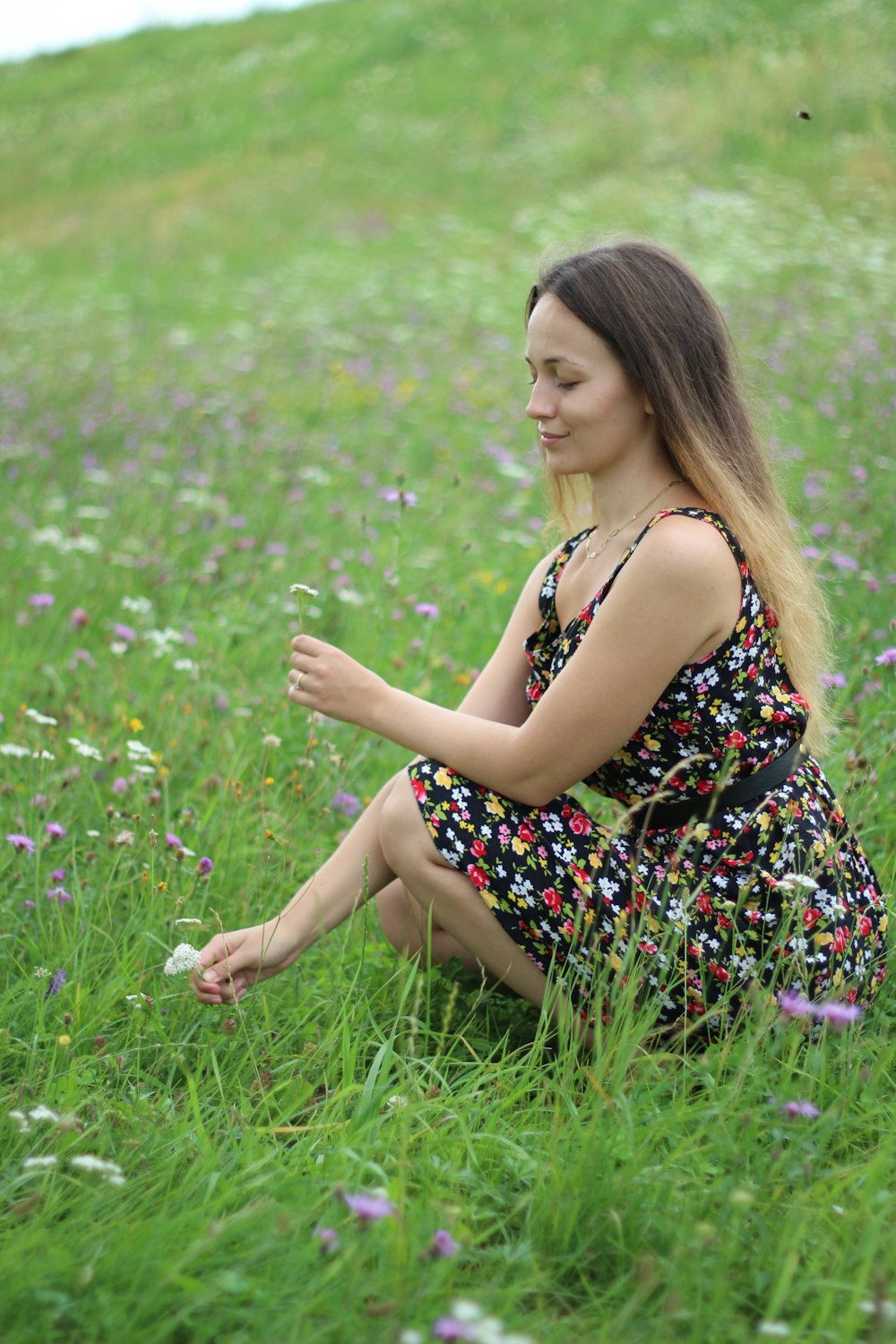 woman crouching on grass field