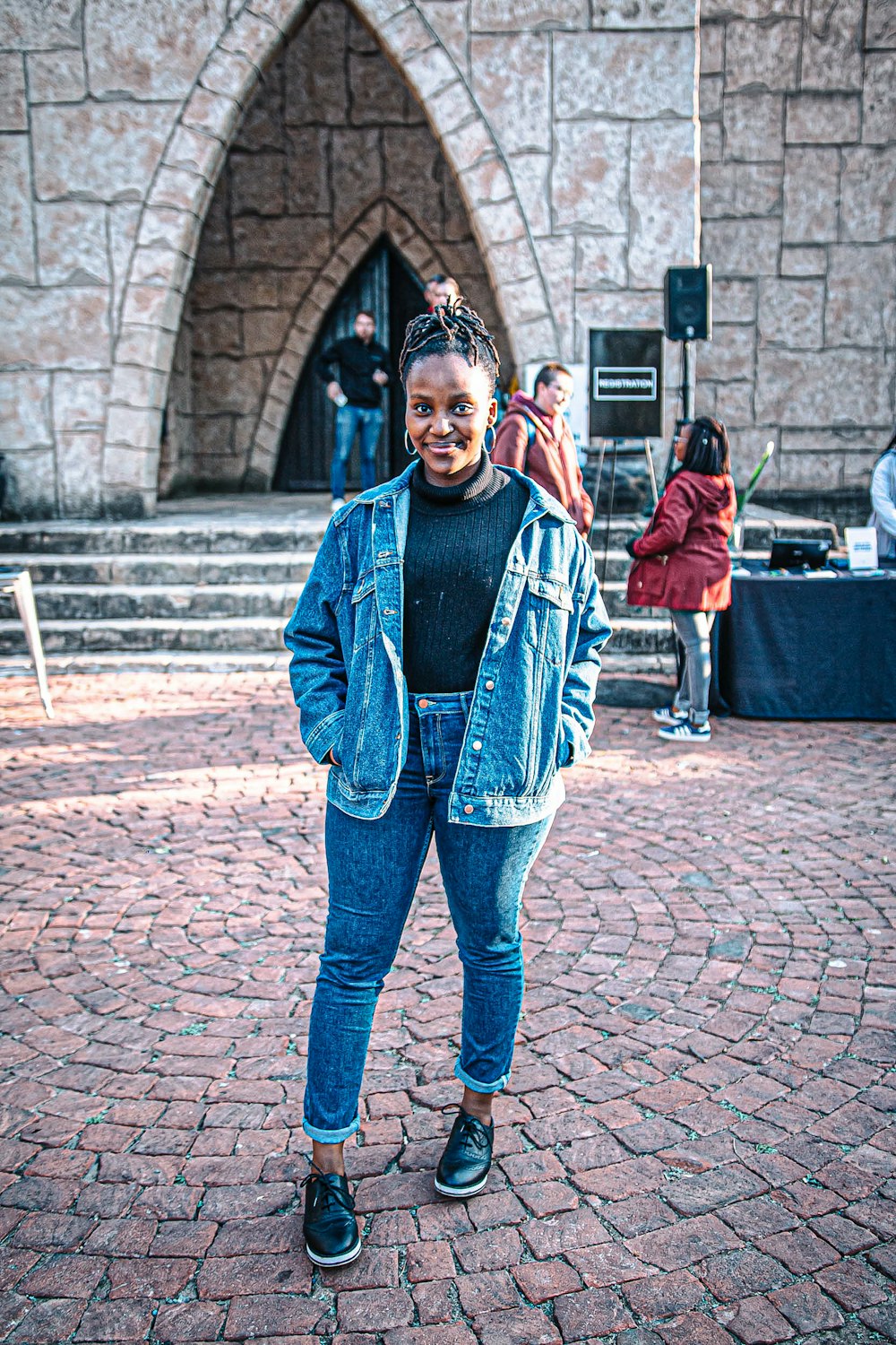 woman smiling and standing near people and building