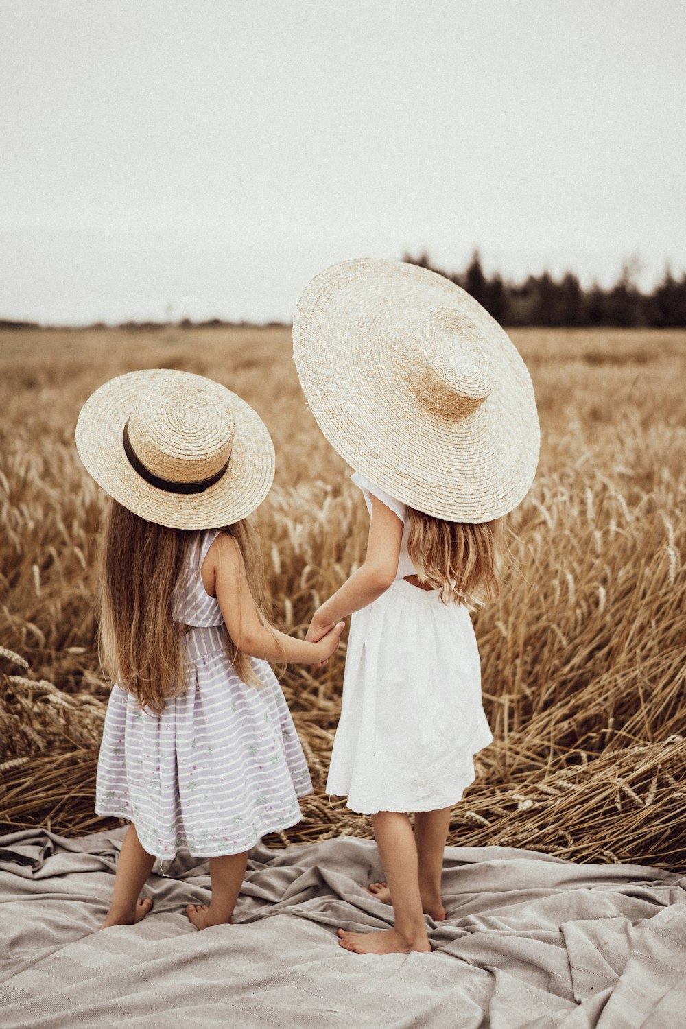 duas meninas usando chapéu de palha