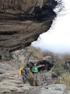 Hikers standing on a cliff edge overlooking the dramatic Komodo island coastline