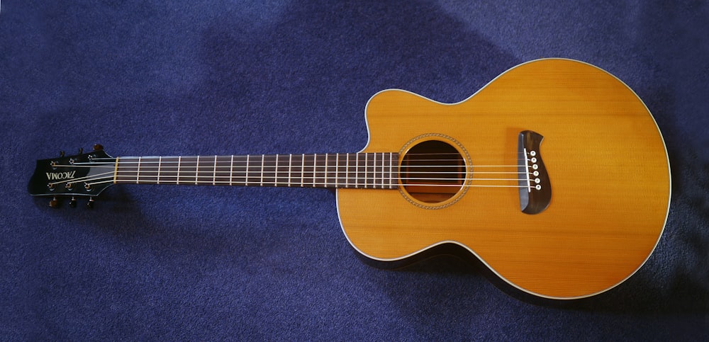 brown single-cutaway acoustic guitar