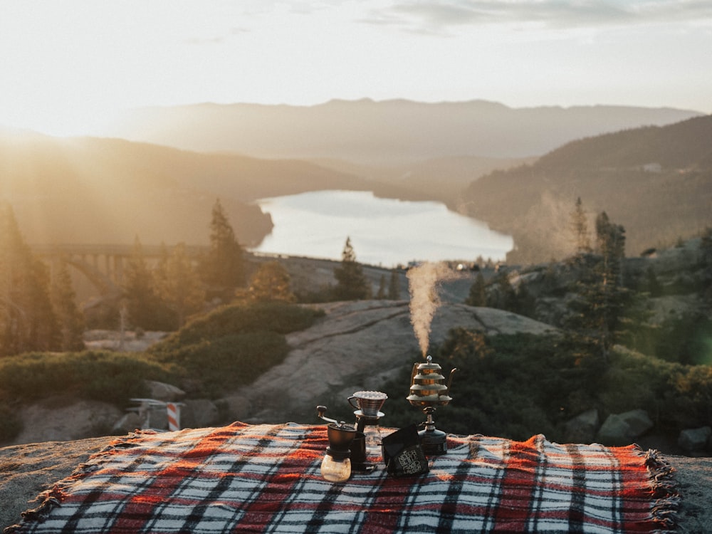 a picnic blanket on top of a mountain overlooking a lake