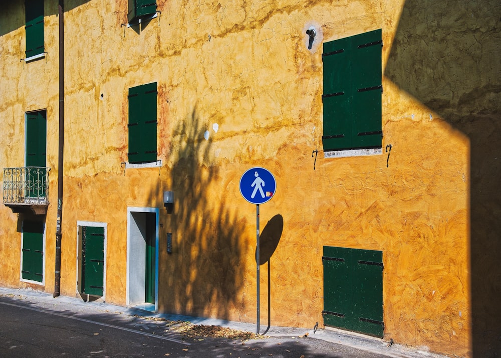 road signage beside yellow building