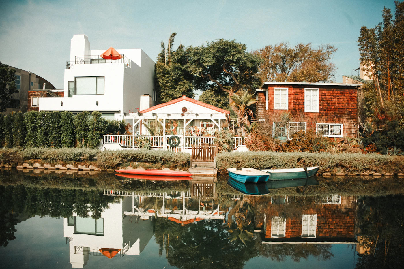 Venice Canals Historic District, Los Angeles — a canal-side home with a boat and palm trees