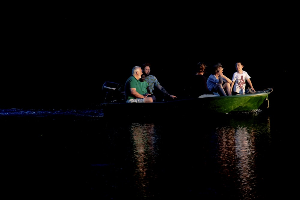 a group of people sitting in a green boat