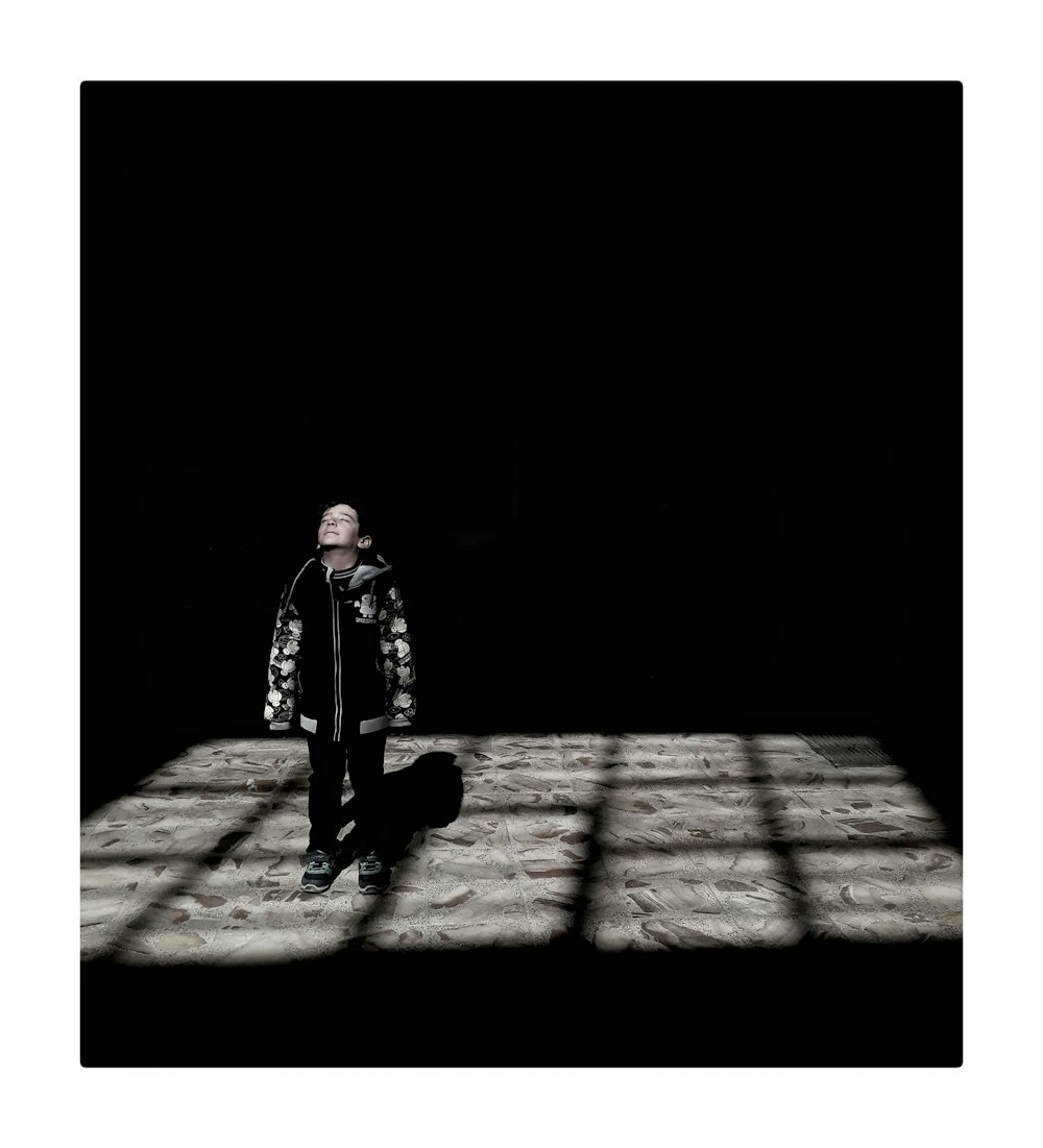 boy standing inside dark room