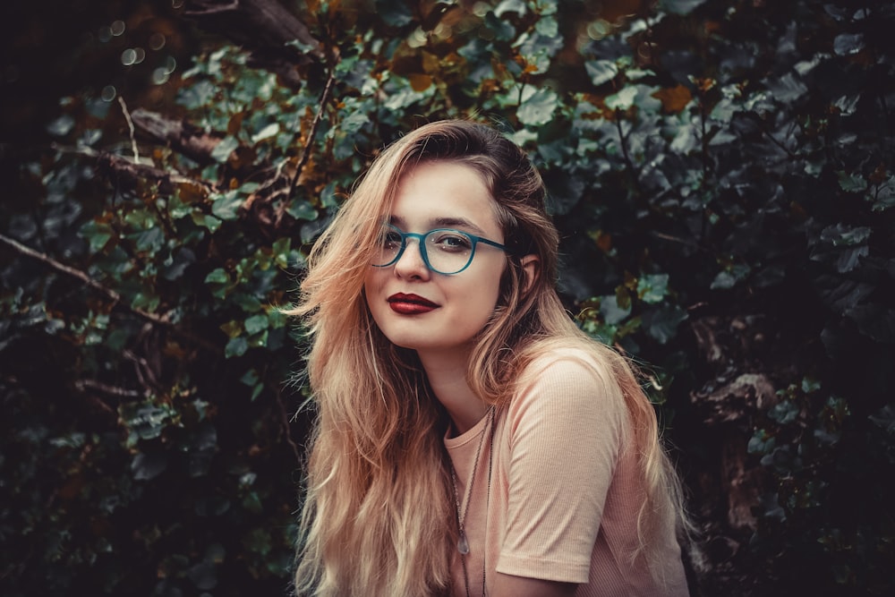 woman standing beside green bush