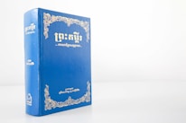 Close-up of a Shakespearean script with Cambodian cultural motifs in the background.