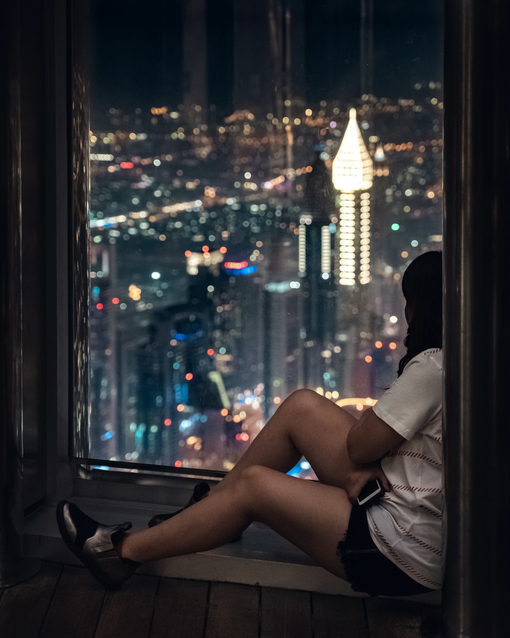 Mujer sentada junto a la ventana durante la noche