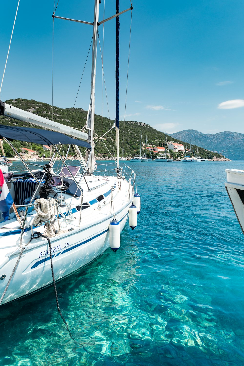 person in white and blue yacht on sea under blue and white skies