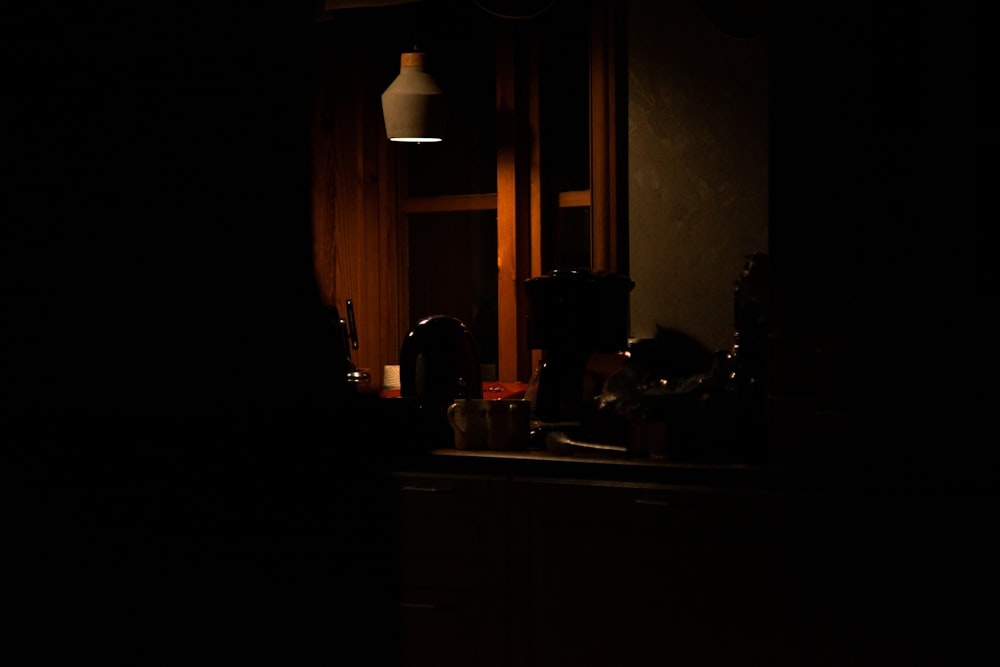 a dark room with a sink and a light
