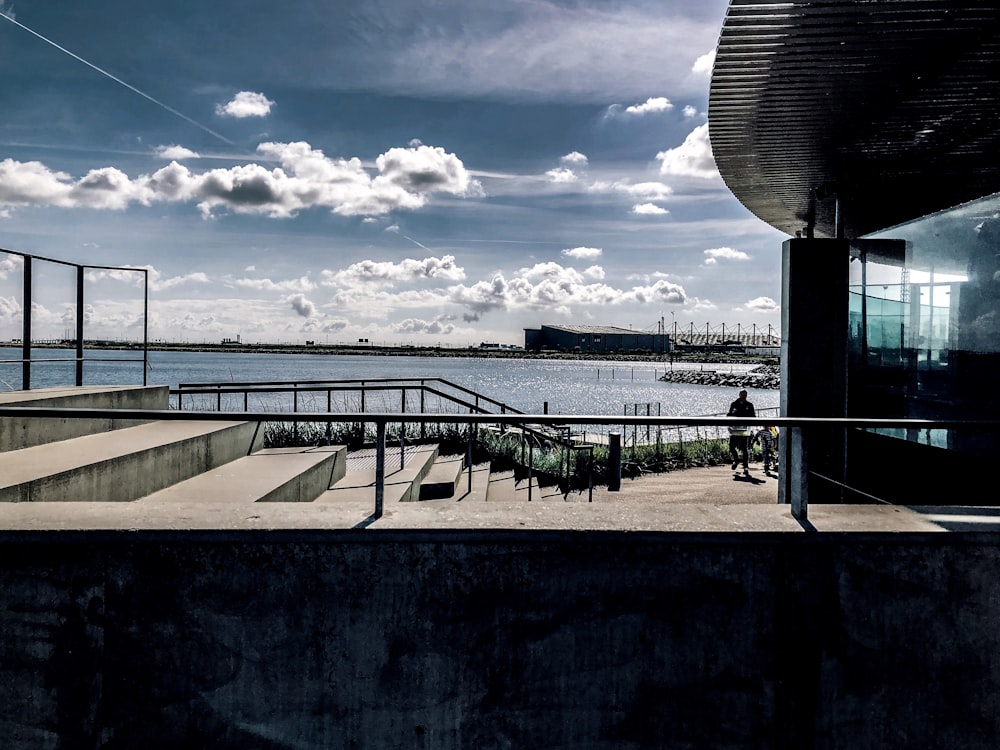 man standing beside building fronting the harbor