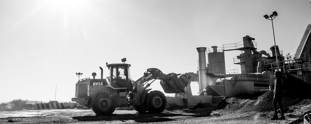 grayscale photography of excavator in front of wall