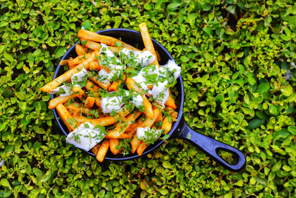 a bowl filled with fries covered in sour cream