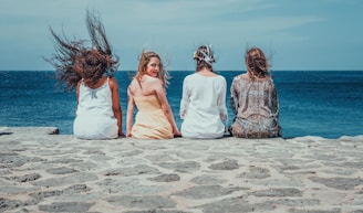 four women sitting on dock