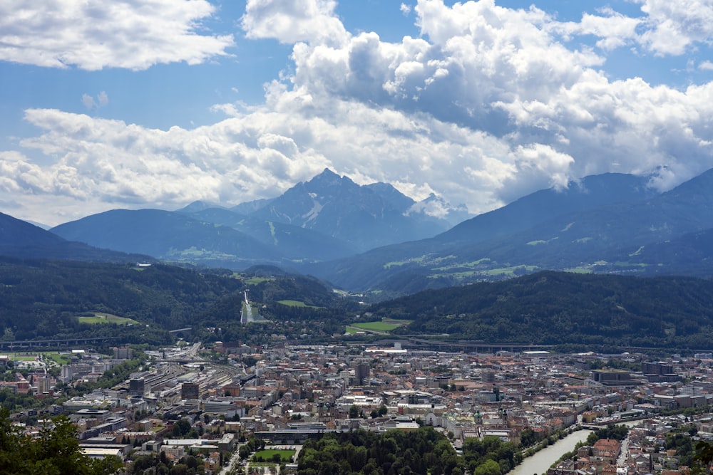 fotografia aerea della città vicino alla montagna sotto il cielo nuvoloso durante il giorno