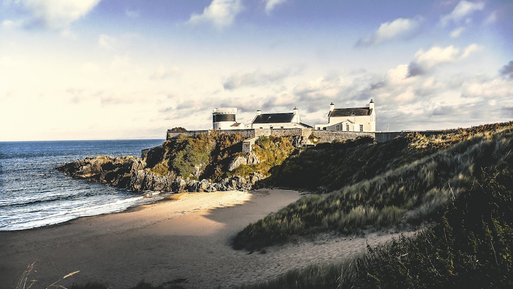 three white concrete houses on sea cliff during daytime