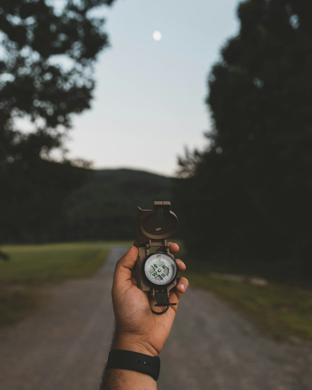 selective focus photography of person holding watch standing on road