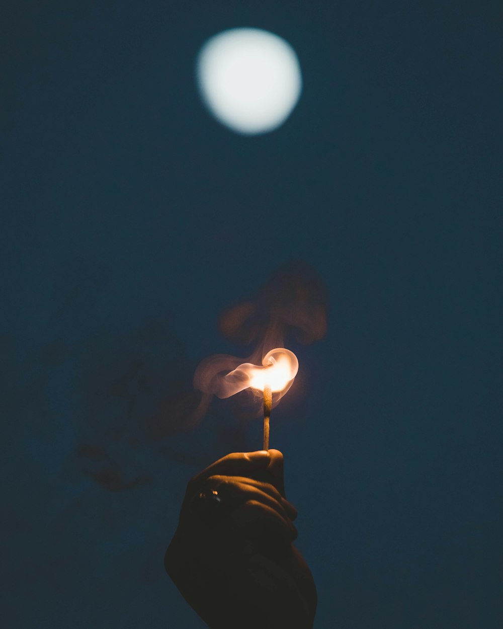 a person holding a lit match in their hand