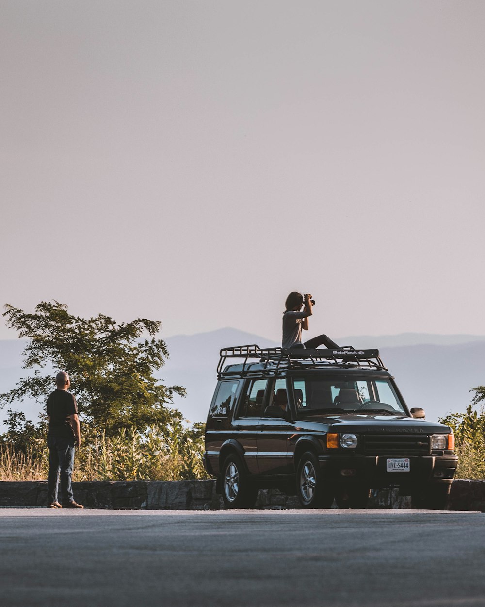 woman sitting on car's roof