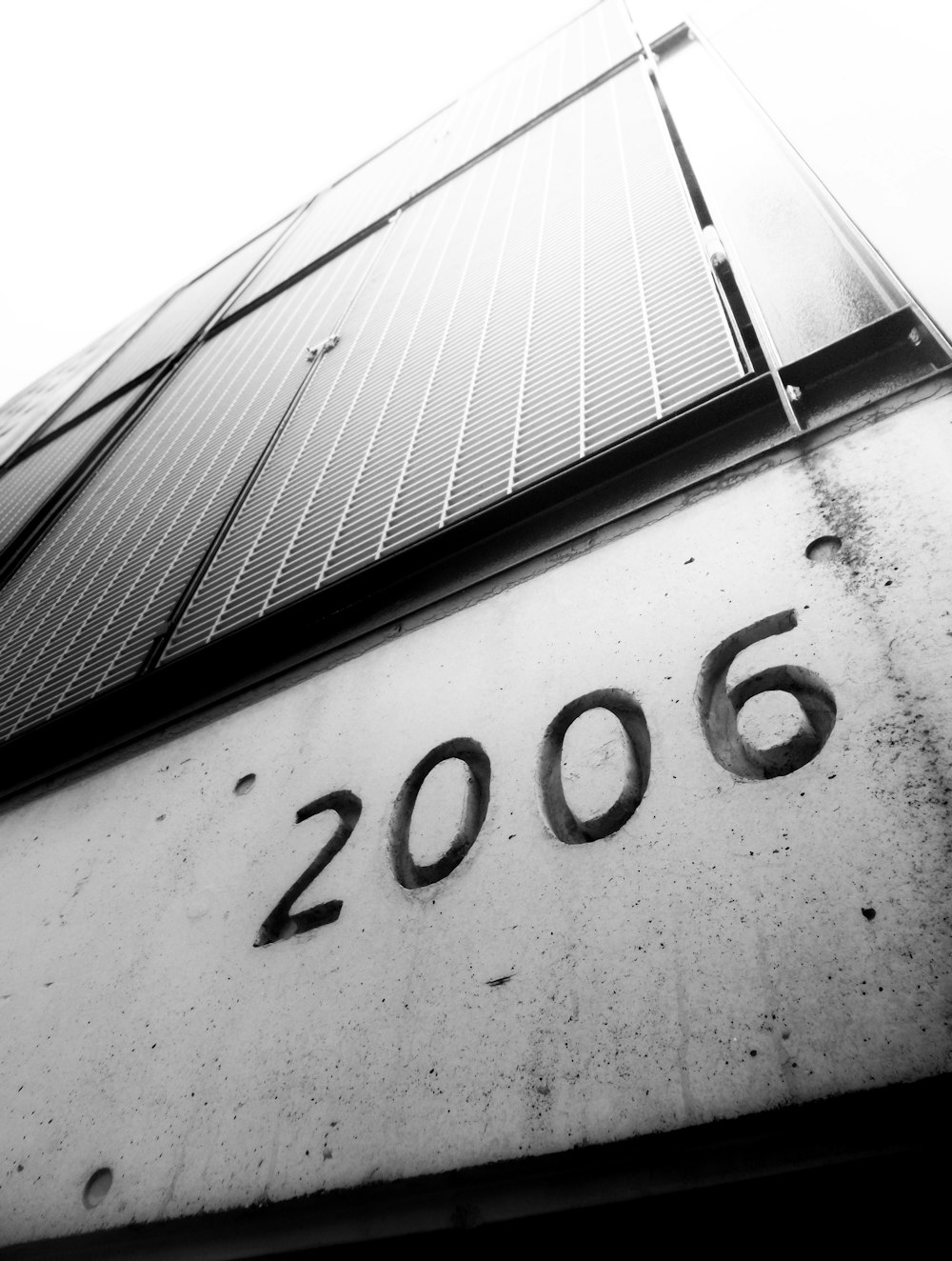 uma foto em preto e branco de um prédio com o número 2006 escrito nele