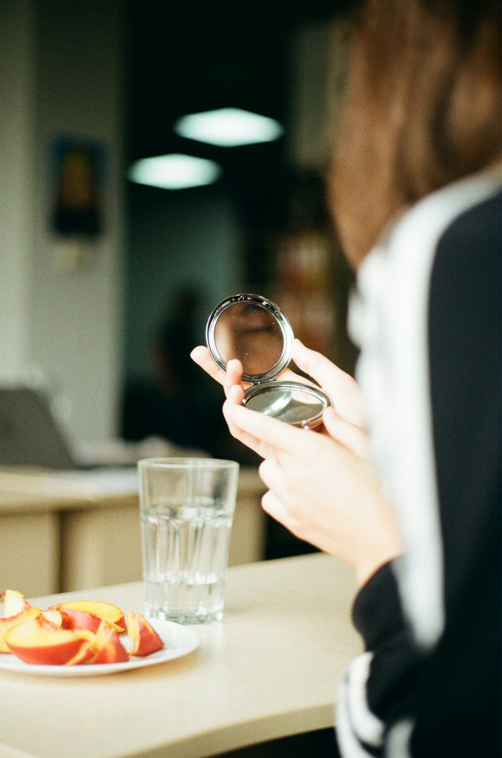 selective focus photography of woman holding folding mirror