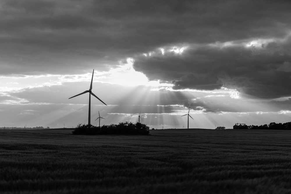 foto in scala di grigi delle turbine eoliche