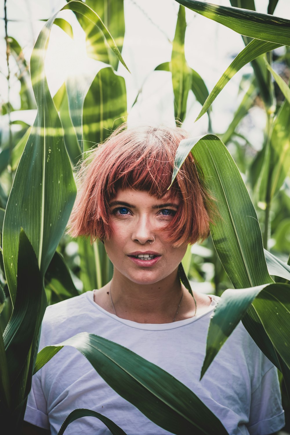 woman in white shirt surrounded by plants