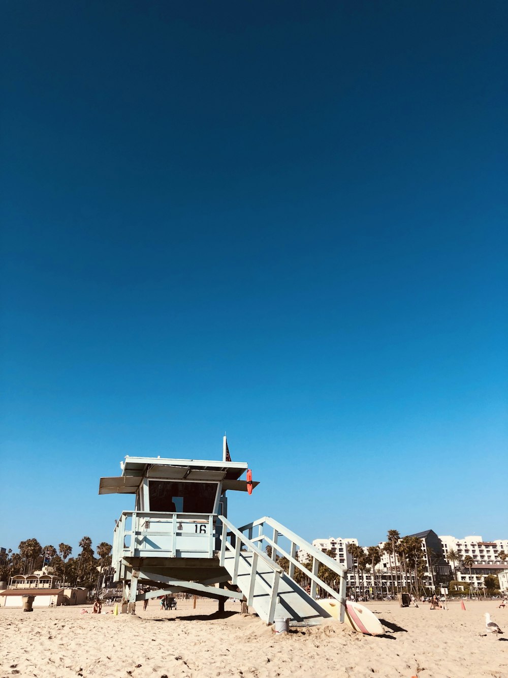 a lifeguard station on a beach with a blue sky in the background