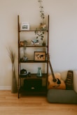 brown wooden 5-layer rack beside dreadnought guitar