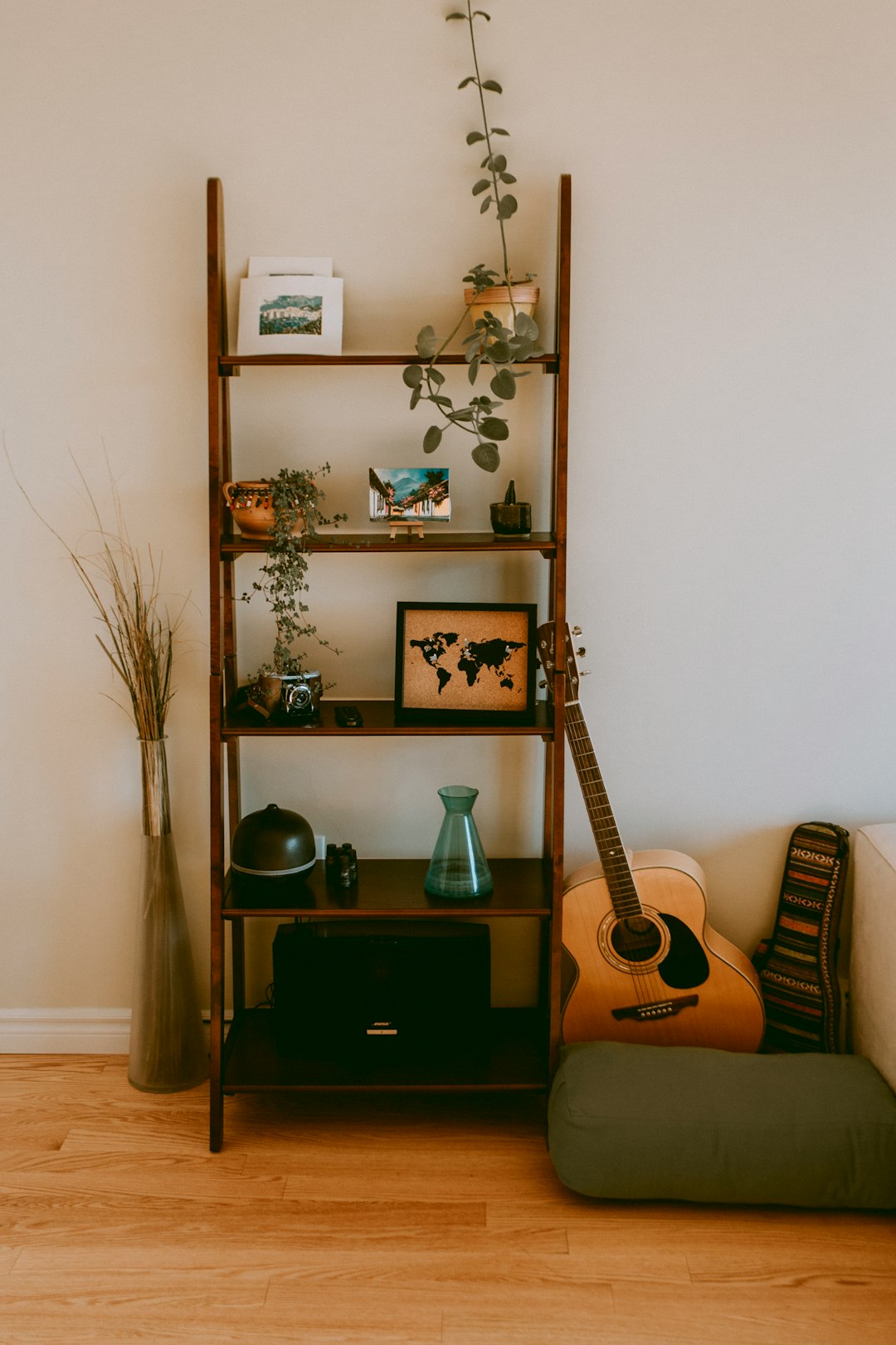  brown wooden 5 layer rack beside dreadnought guitar bookcase