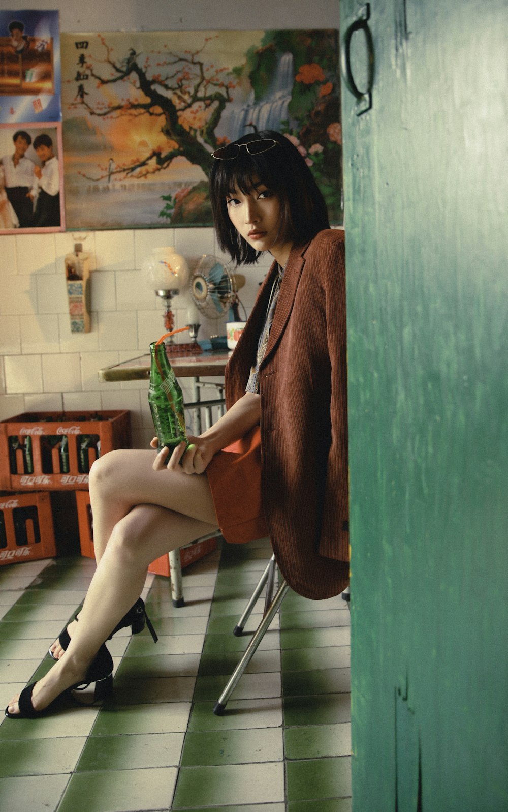 a woman sitting on a chair holding a bottle