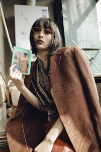 A soft-lit editorial shot of a poised model reviewing a portfolio in a sleek velvet-draped office.