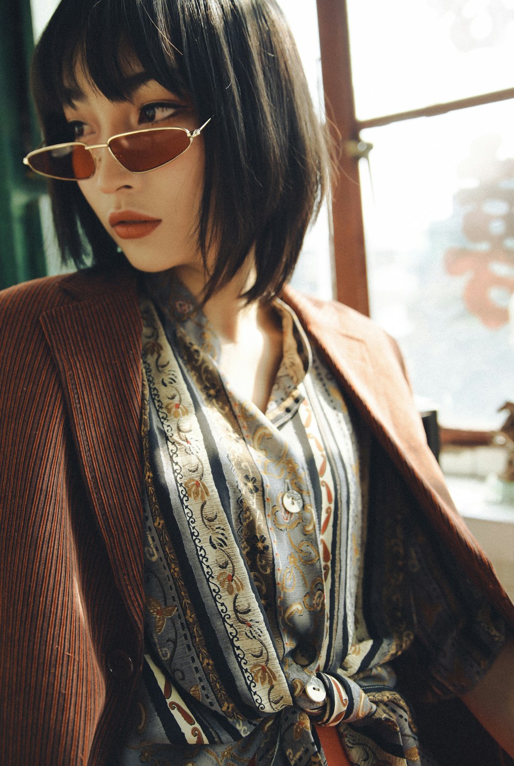 woman in brown suit jacket sitting by the table