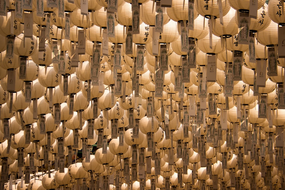 Une pièce remplie de nombreuses lanternes en papier suspendues au plafond