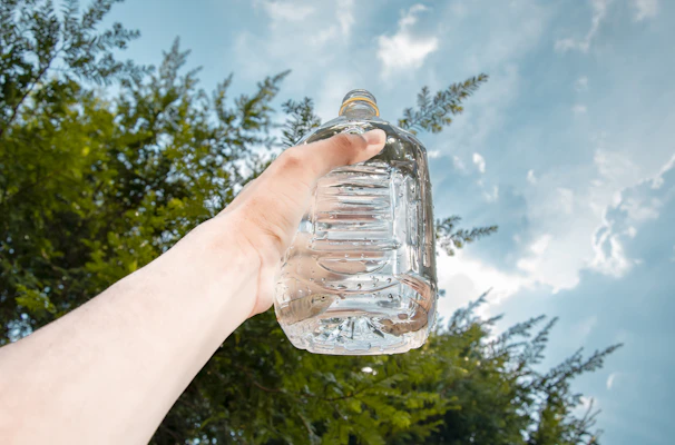 Hands holding a transparent plastic plate showcasing its strength and clarity.