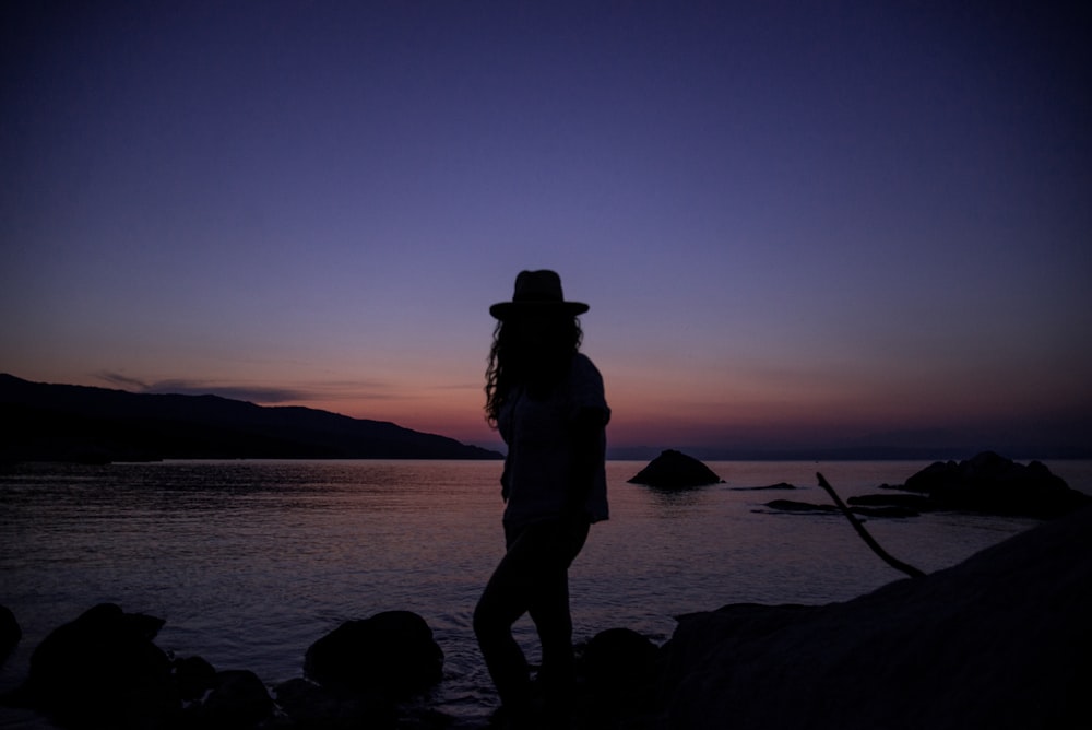 silhouette of person near ocean