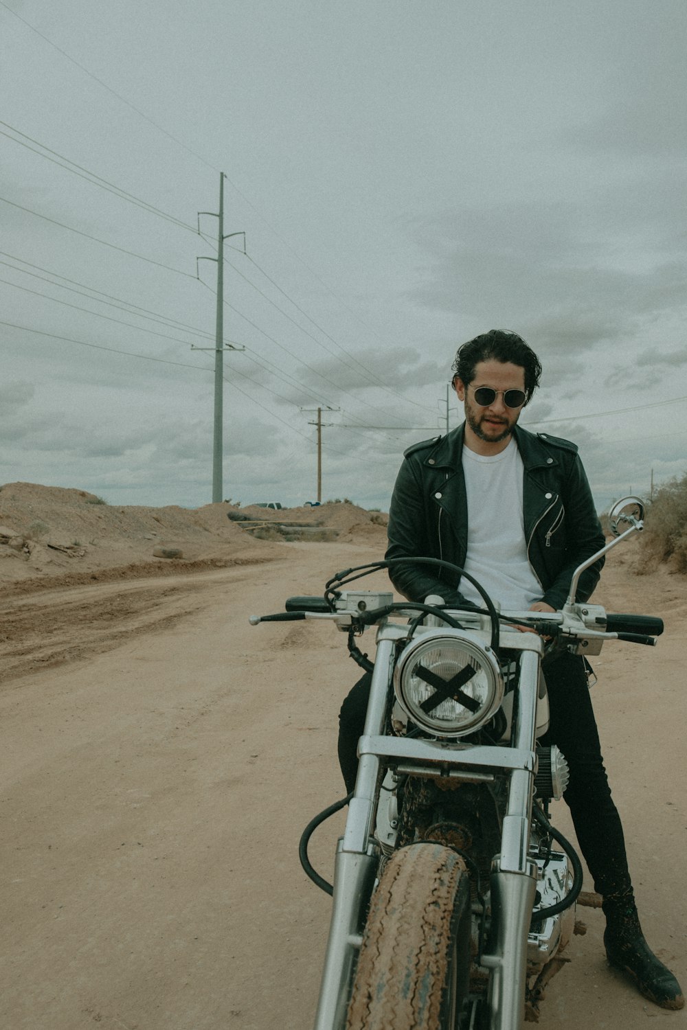 man wearing black leather jacket riding on motorcycle during daytime