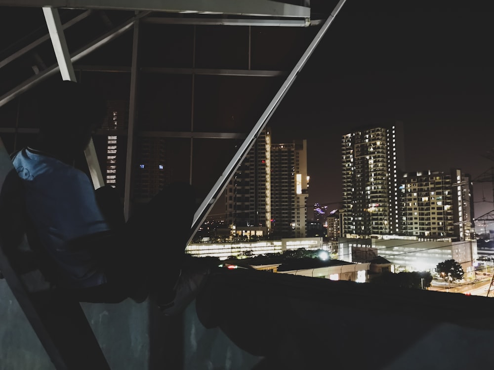 a man standing on top of a roof next to a tall building