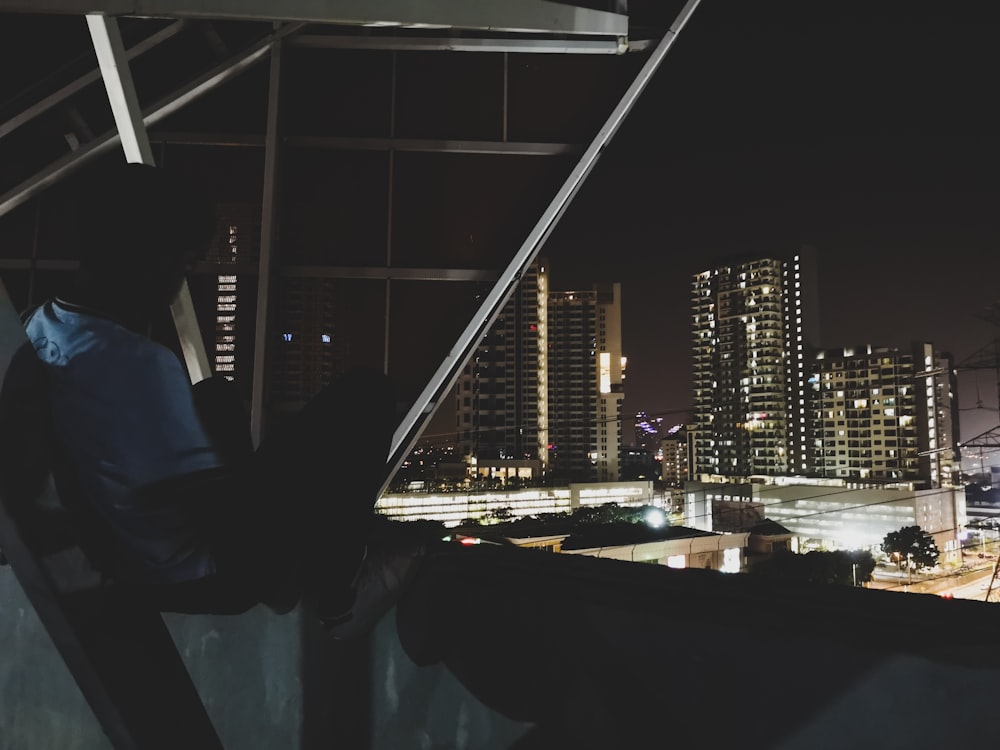 Ein Mann, der auf einem Dach neben einem hohen Gebäude steht